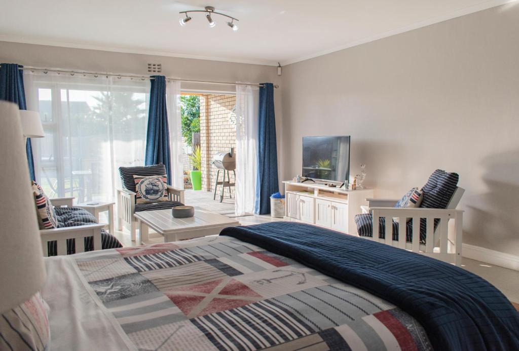 a bedroom with a bed and chairs and a window at Settle inn Self Catering Units in Colchester