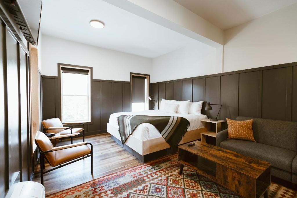 ein Hotelzimmer mit einem Bett und einem Sofa in der Unterkunft The Flying Steamshovel Inn in Rossland