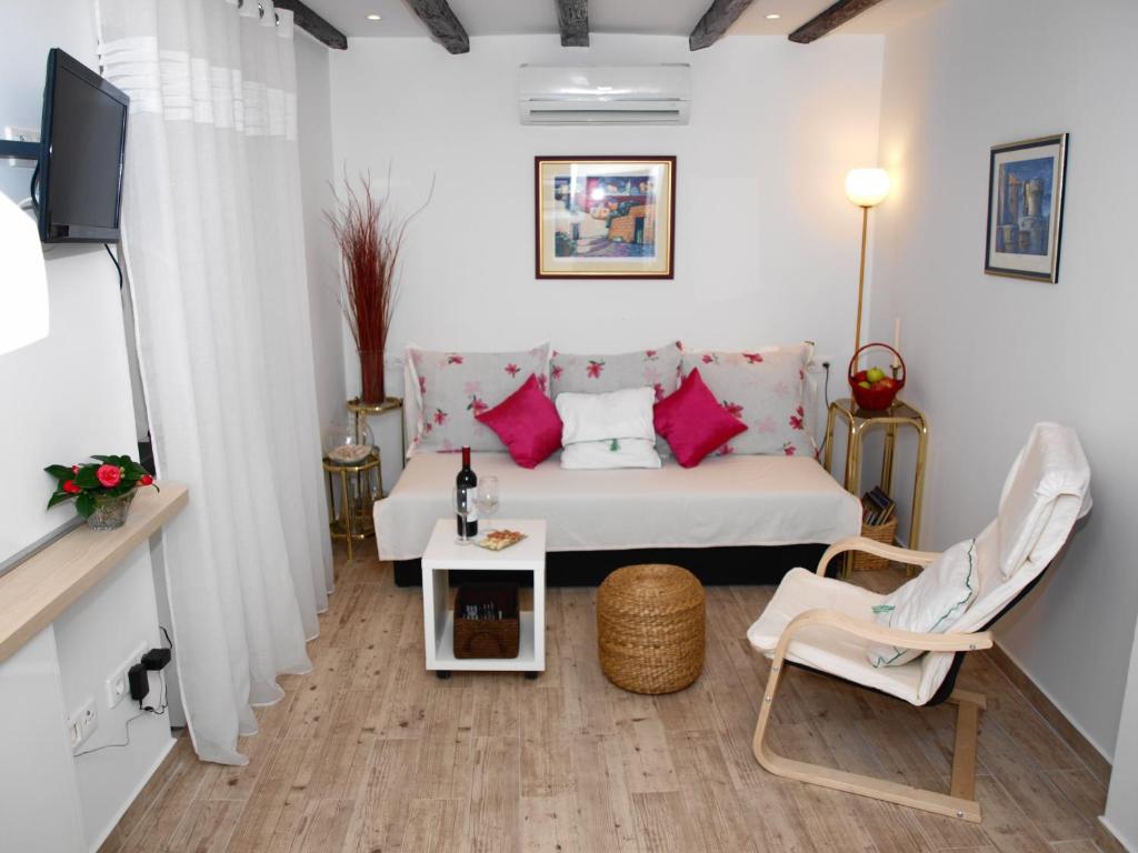 uma pequena sala de estar com uma cama e um sofá em Apartment Bonbon em Dubrovnik