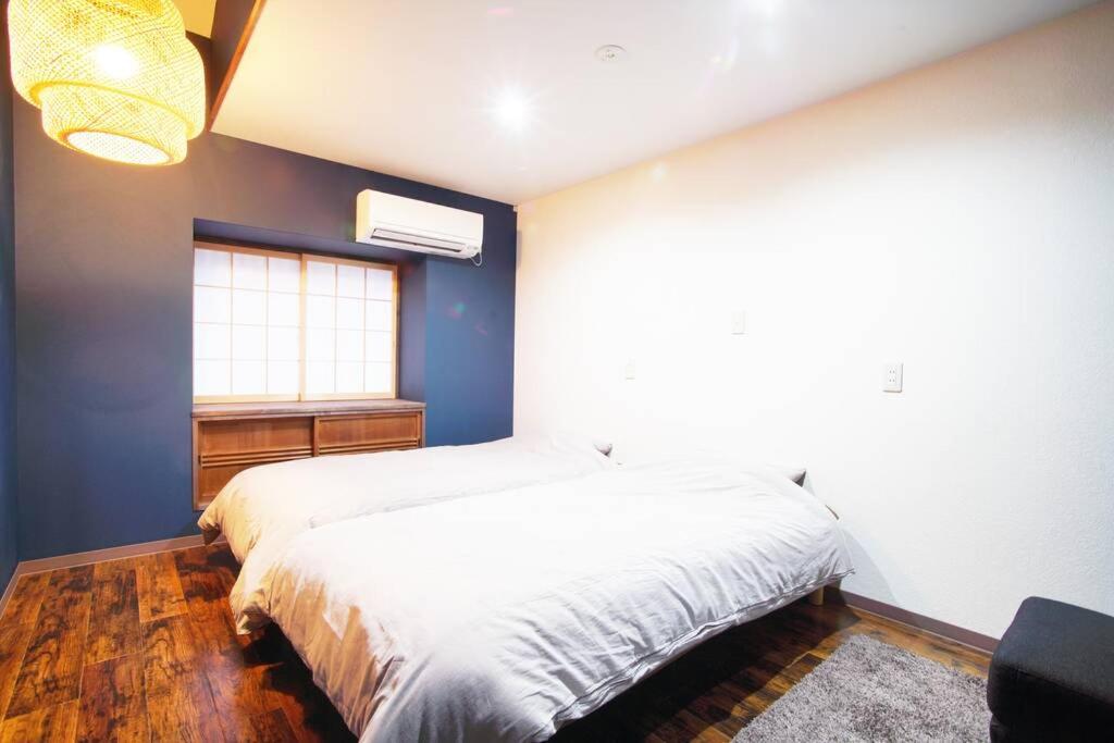 a bedroom with a white bed and a window at Inuicho Tori in Kyoto