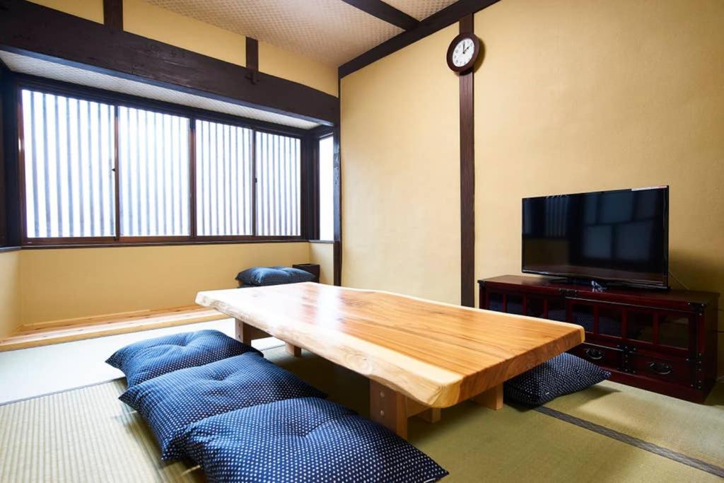 un soggiorno con tavolo in legno e TV di Inokuma Kita a Kyoto