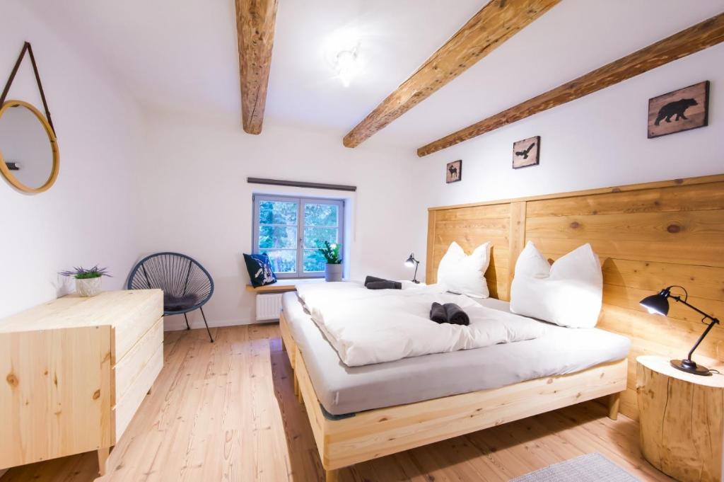 a bedroom with a large bed with a wooden headboard at FarmHouse Eckartsberg im Zittauer Gebirge - Ferienwohnung mit 2 Schlafzimmern, Terrasse und WALLBOX in Mittelherwigsdorf