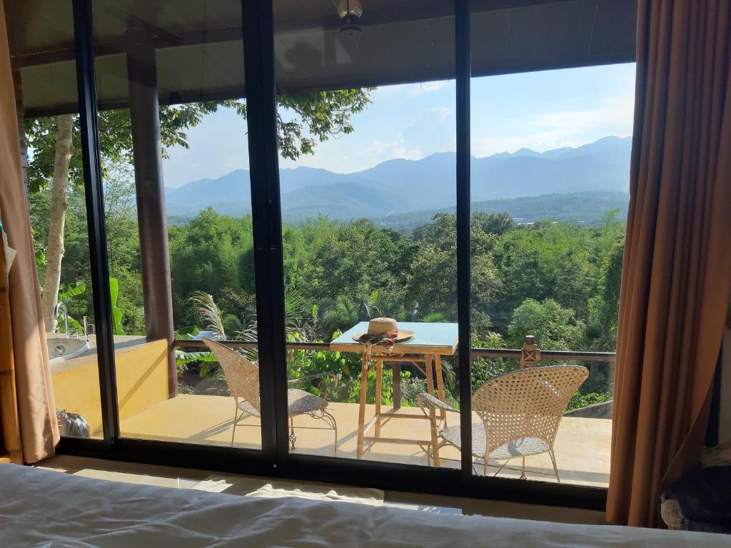 a room with a view of the mountains through a window at Chang Pai Hill in Pai