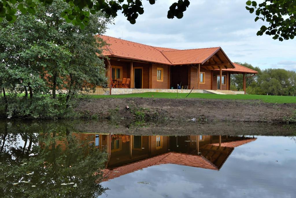 een huis met een reflectie in het water bij Majorka Vendégház in Diósjenő