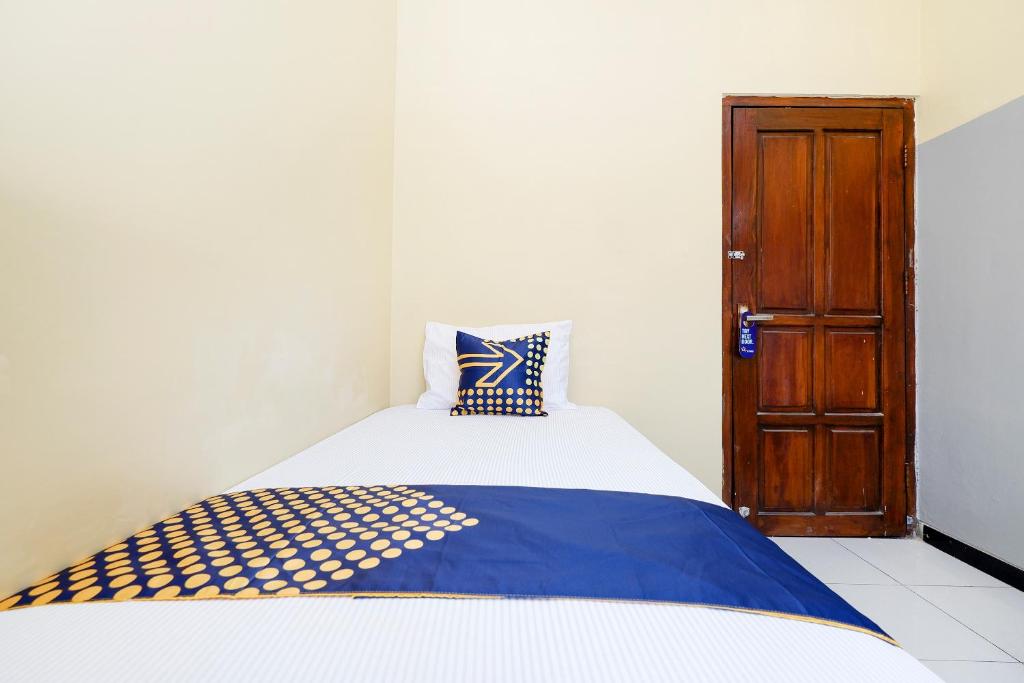 Postel nebo postele na pokoji v ubytování SUPER OYO 2209 Solo Point Guest House Syariah