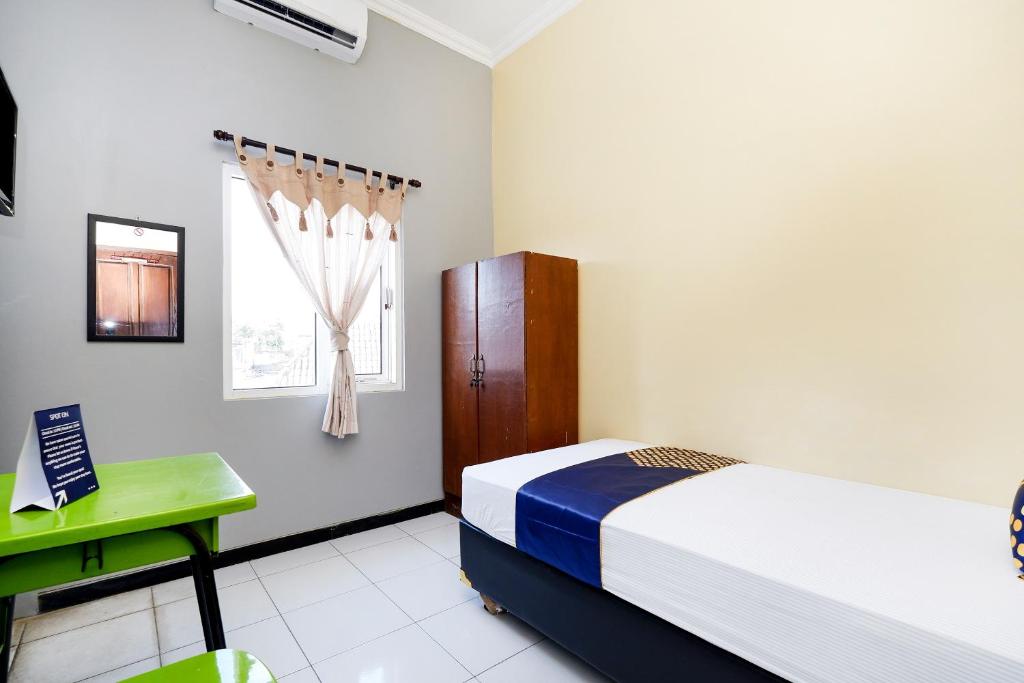 Postel nebo postele na pokoji v ubytování SUPER OYO 2209 Solo Point Guest House Syariah