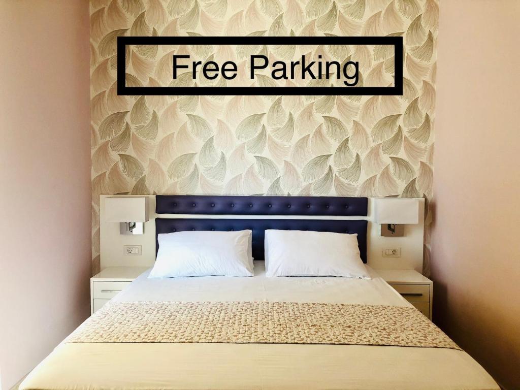 a bedroom with a bed with a free parking sign above it at Lovely Apartments in Patra