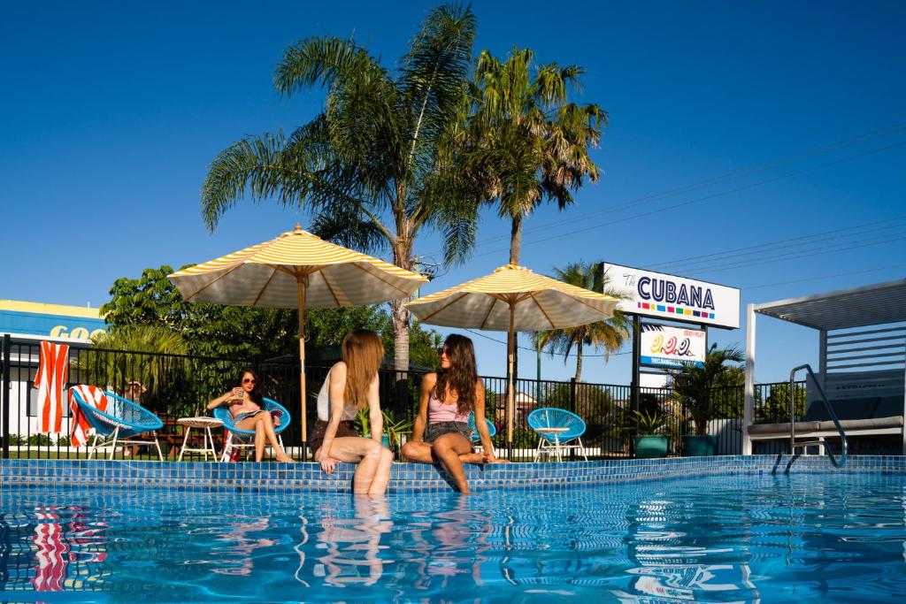 duas mulheres sentadas à beira de uma piscina em The Cubana Ballina em Ballina