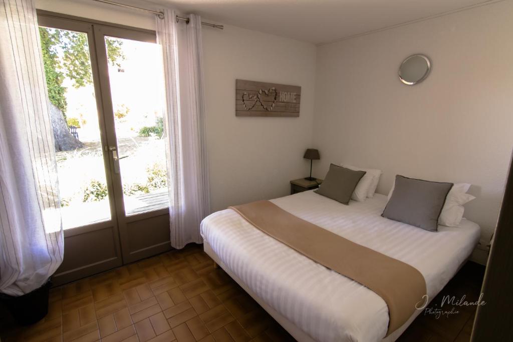 Postel nebo postele na pokoji v ubytování LOGIS HOTELS - Hôtel et Restaurant L'Océana