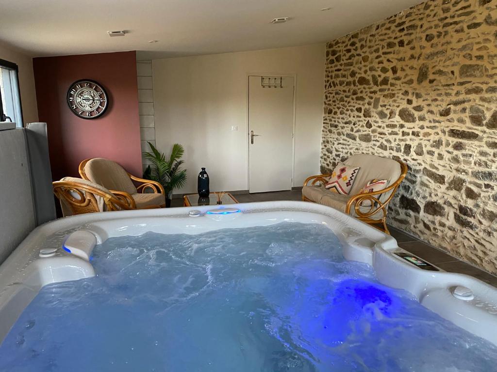 a jacuzzi tub in a room with chairs at Maison d'hôtes & Gîtes Domaine de la Garaye in Dinan