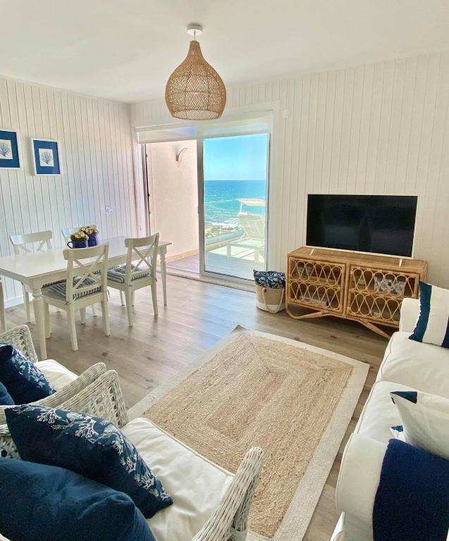 a living room with a couch and a tv and a table at BBA Moledo - Beachfront Apartment in Moledo