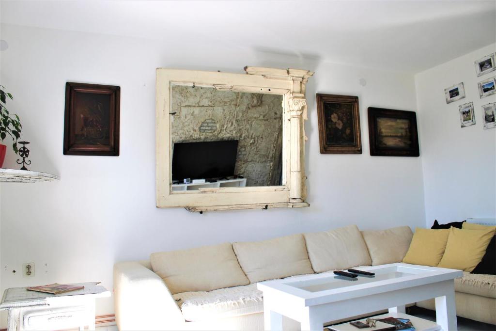 ein Wohnzimmer mit einem Sofa und einem Spiegel in der Unterkunft Mala Oaza in Čačak