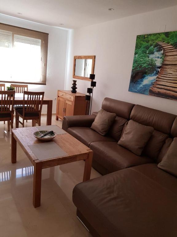 Hotel HR PARADISE RESIDENCIAL LOIX, a living room with a couch and a table at HR PARADISE RESIDENCIAL LOIX in Benidorm