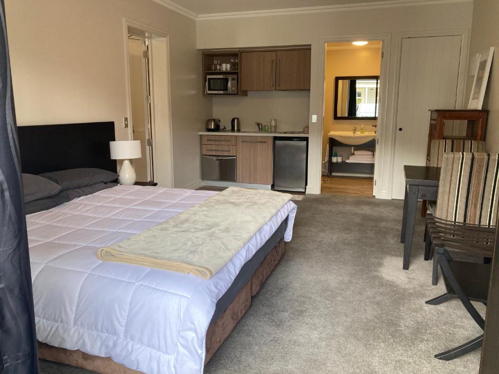 a bedroom with a large bed and a kitchen at Cardrona Valley Studio (17) in Cardrona