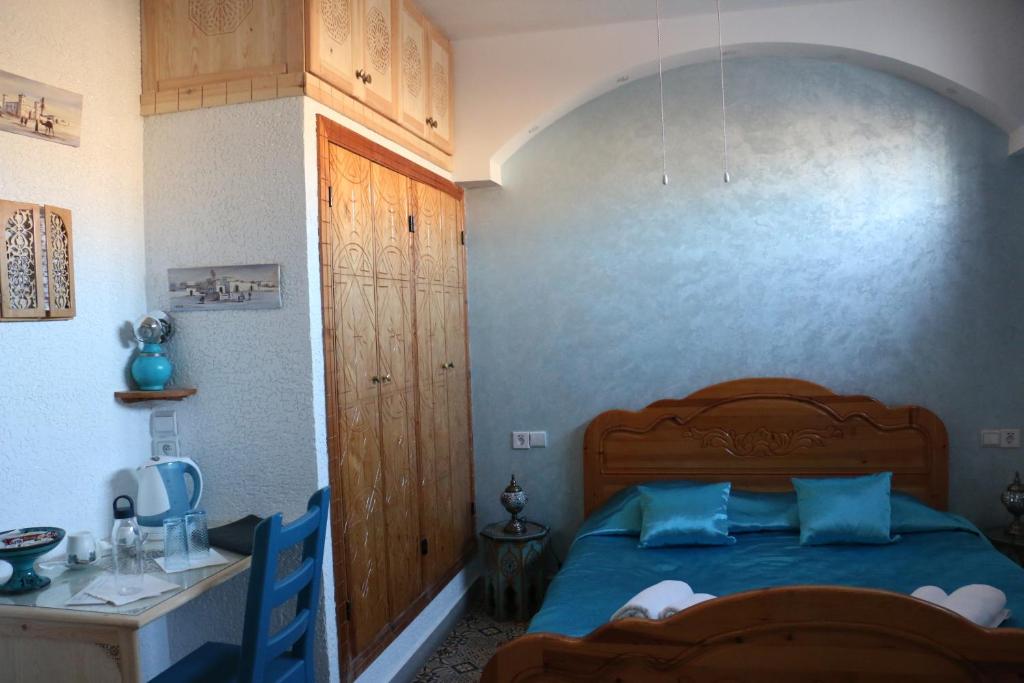 a bedroom with a blue bed and a desk at Riad Les Chtis D'Agadir in Agadir