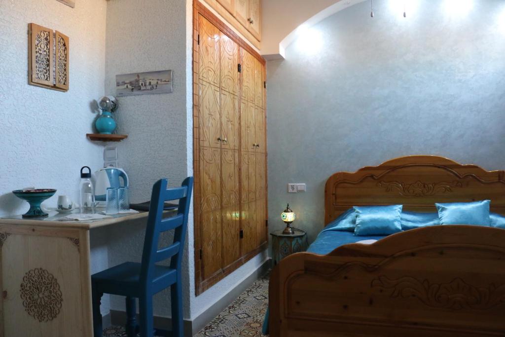 a bedroom with a bed and a table and a chair at Riad Les Chtis D'Agadir in Agadir