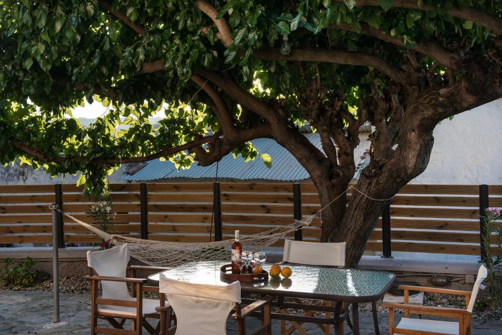 stół i krzesła siedzące pod drzewem w obiekcie Maro's Village Private Stone Villa w Chanii