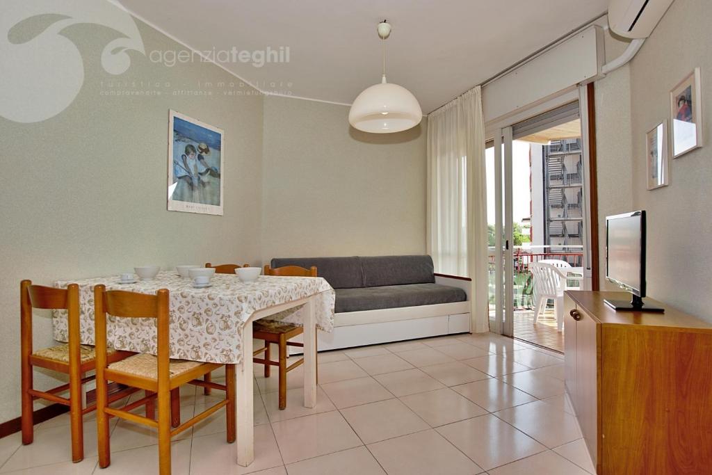 - un salon avec une table et un canapé dans l'établissement Condominio Cristallo, à Lignano Sabbiadoro