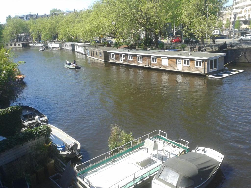 a boat is docked on a river with a house at Canal View in Amsterdam