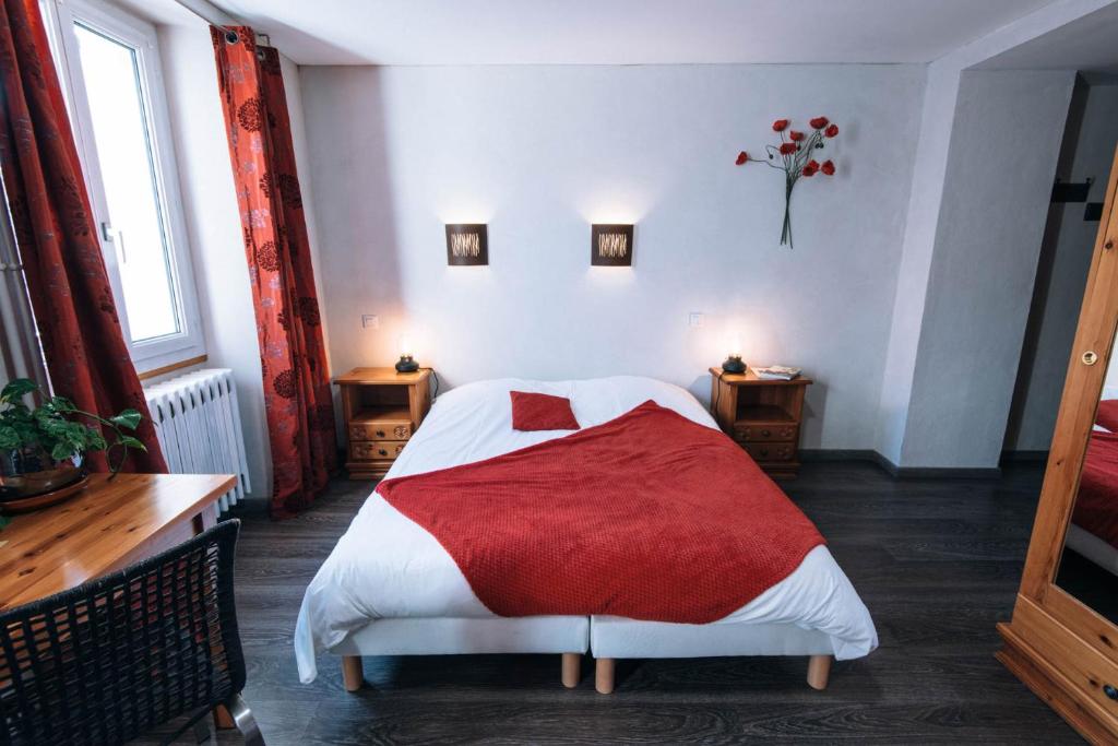 een slaapkamer met een bed met een rode deken bij Chalet de Lanza in Abriès