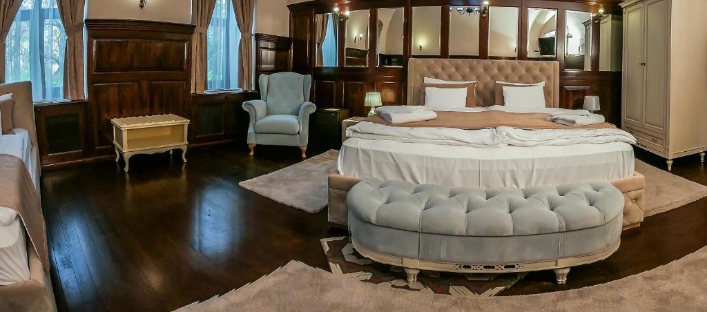 a large bedroom with a large bed and a chair at Belga Boutique Hotel in Debrecen
