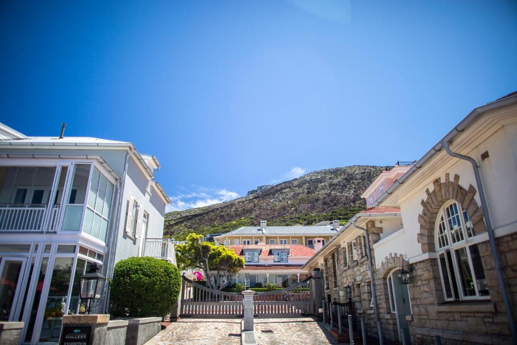 a city street with buildings and a mountain in the background at The Majestic Apartments in Kalk Bay