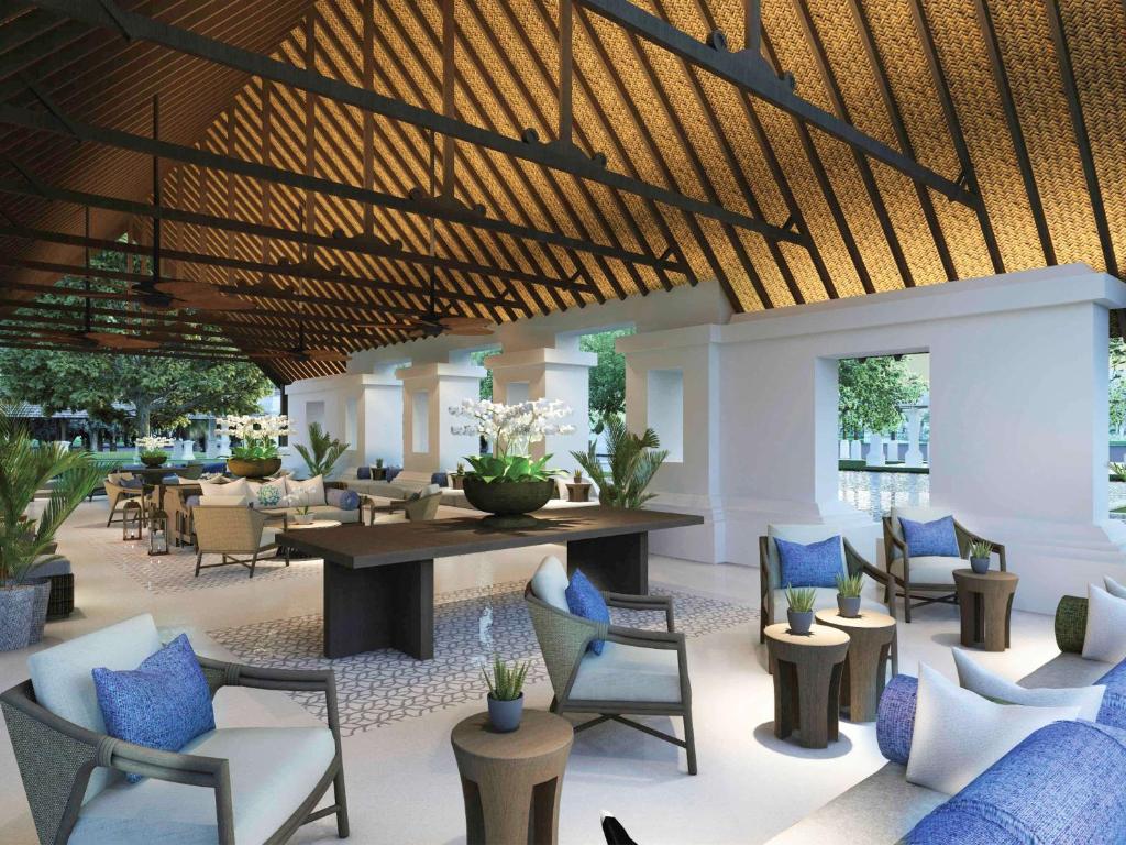 een lobby met stoelen en een tafel en tafels en stoelen bij Novotel Bogor Golf Resort in Bogor