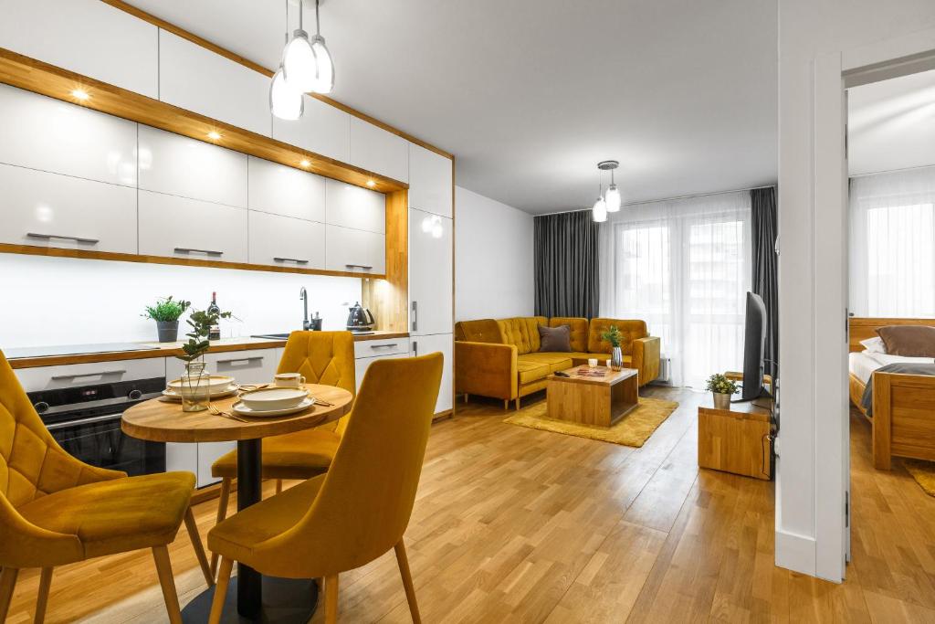 a kitchen and living room with a table and chairs at Emihouse CityVibe Apartments in Rzeszów