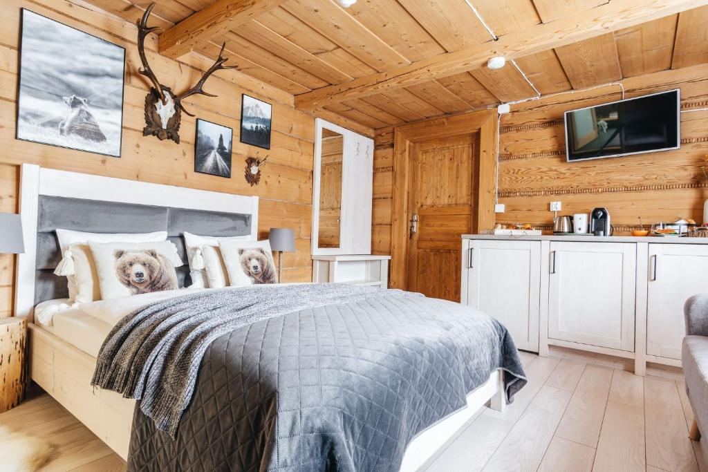ein Schlafzimmer mit einem Bett in einer Holzhütte in der Unterkunft Sichlańskie Spanie in Murzasichle