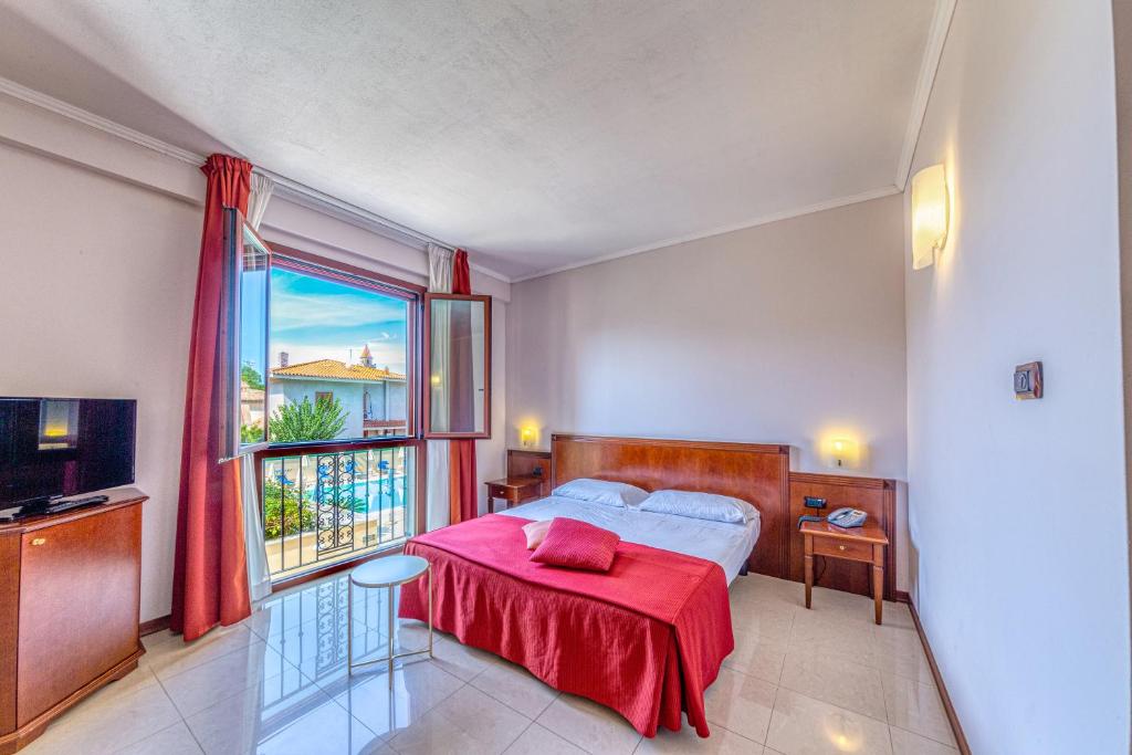 ein Schlafzimmer mit einem Bett und einem großen Fenster in der Unterkunft Hotel Le Torri in Arborea 