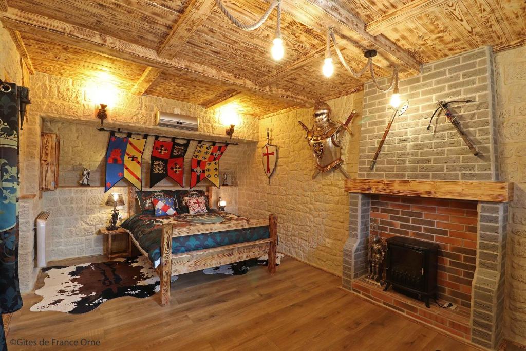 um quarto com lareira e uma cama em chambre d'hôte medieval du vieux bourg em Chailloué