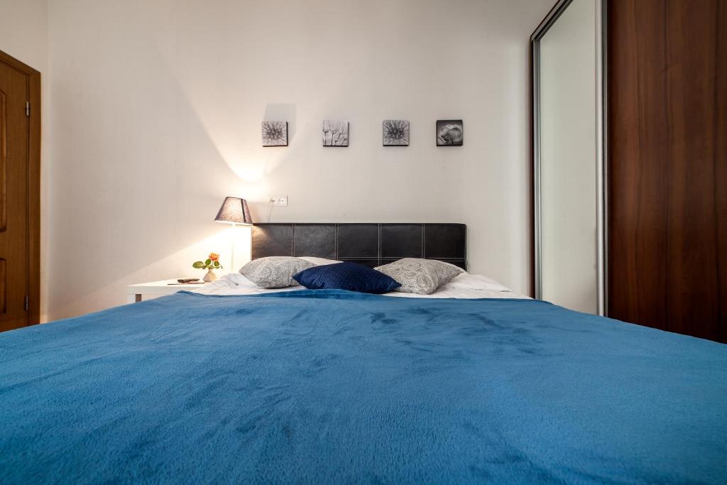 een groot bed met een blauwe deken erop bij Apartment on Virmens`ka Street in Lviv