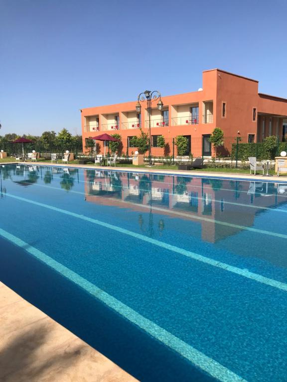 a large swimming pool in front of a building at Palais Benfatah in Marrakesh