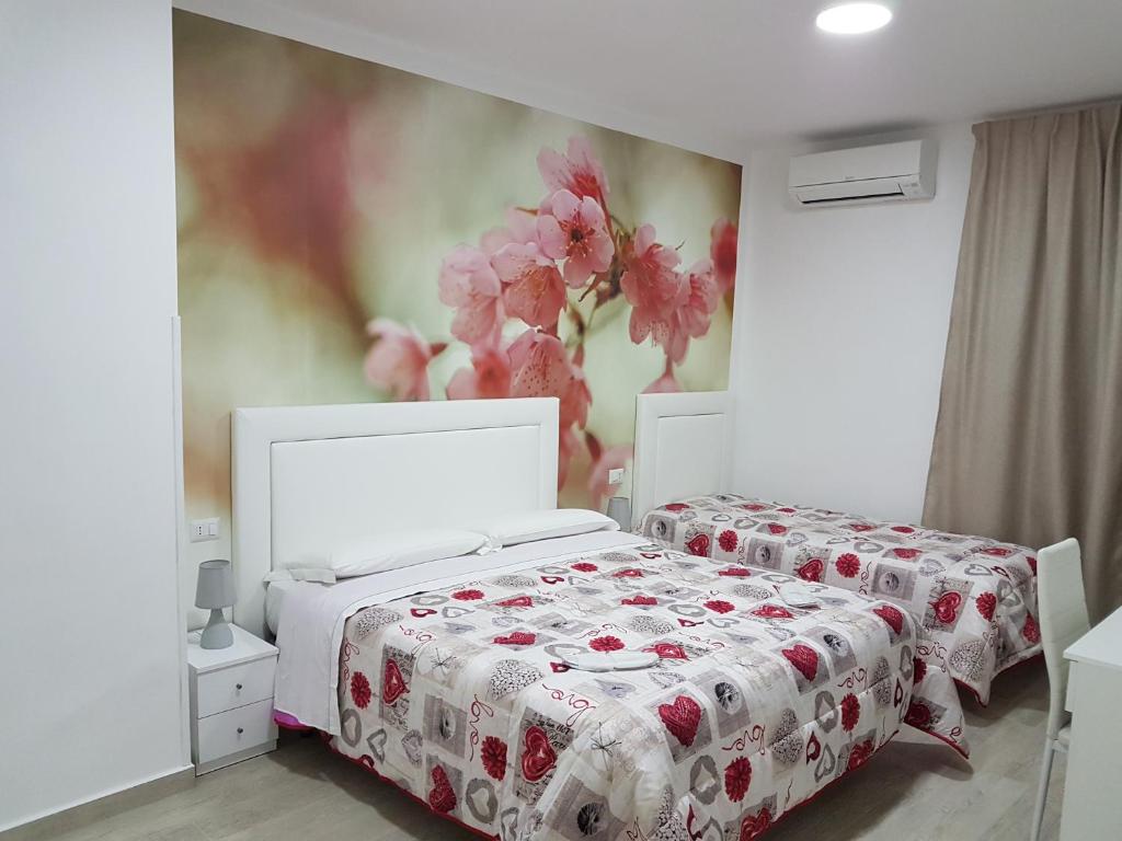 1 dormitorio con 2 camas y un cuadro en la pared en Napoli Relais, en Nápoles