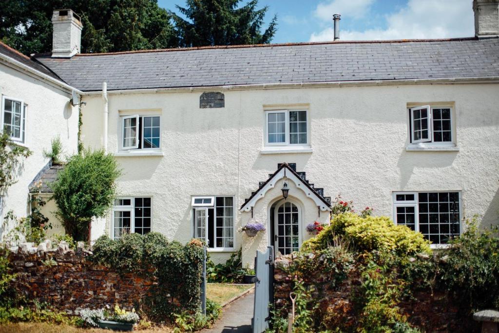 a white house with a garden in front of it at Deer's Leap Retreat in West Anstey