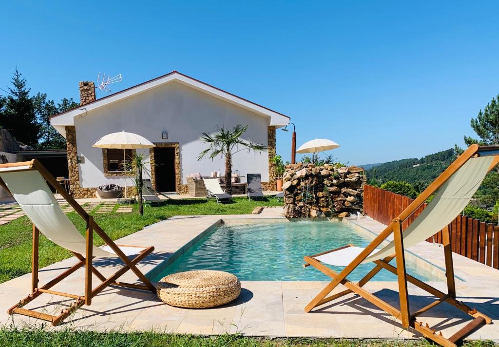 a pair of chairs and a pool in front of a house at Casa Mira Tâmega in Marco de Canaveses