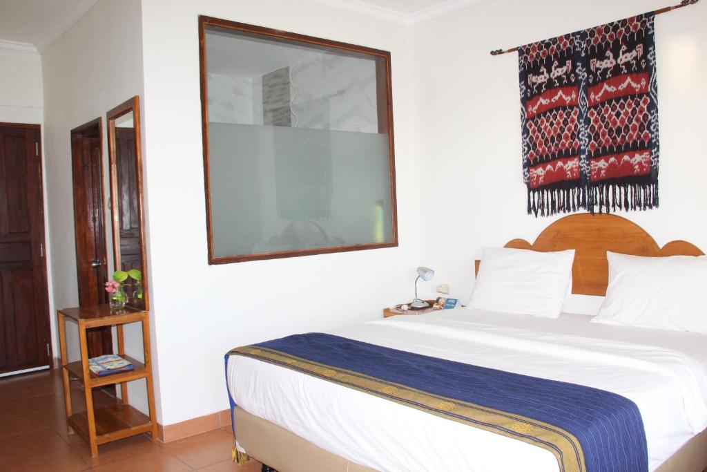 a bedroom with a large white bed in a room at Mario Hotel and Cafe in Weetebula