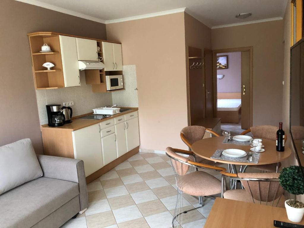 kuchnia i salon ze stołem i kanapą w obiekcie József Apartments House w Zalakaros