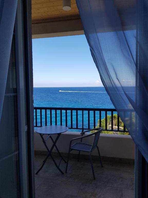 balcón con mesa y vistas al océano en Maison Bella Vista, en Cagnano