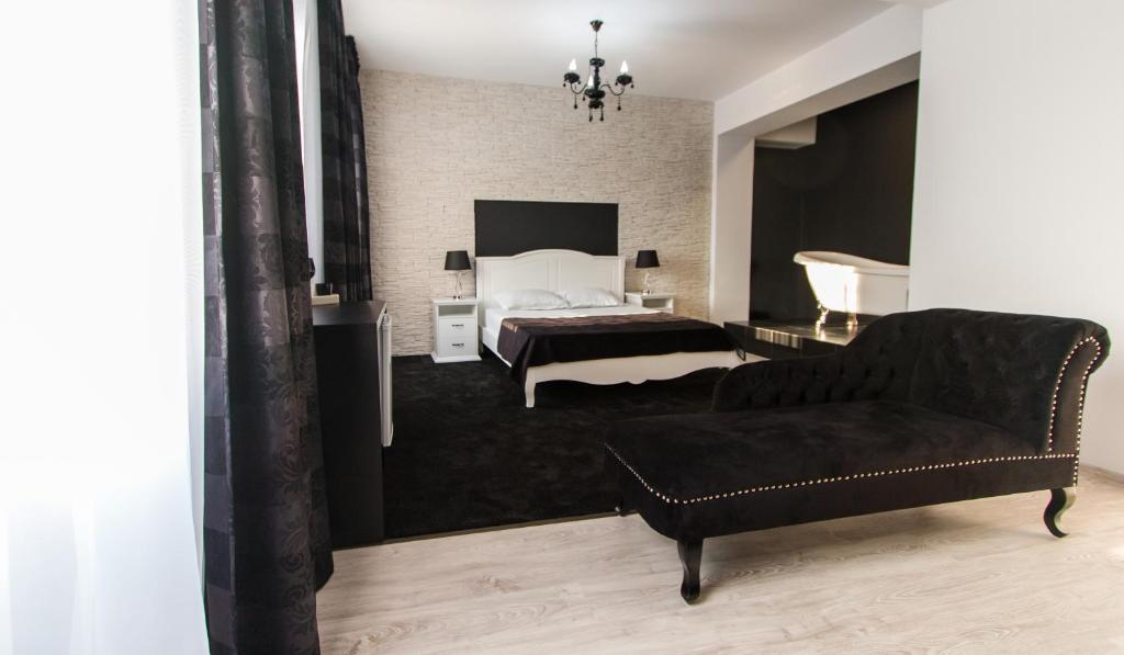 een slaapkamer met een bed en een bank en een bed bij Hotel Evianne Boutique in Galaţi