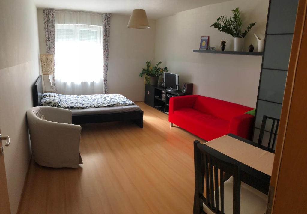 ブダペストにあるCozy Apartment in District 8のリビングルーム(赤いソファ、赤い椅子付)