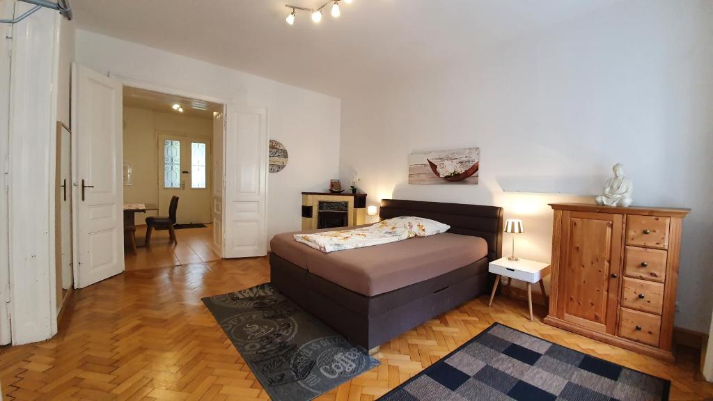 a bedroom with a bed and a dresser in it at Gorgeous Viennese Apartment 10 min to City Center in Vienna