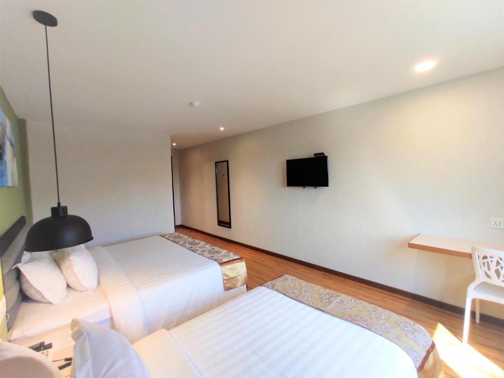 Postel nebo postele na pokoji v ubytování Apple Suites Hotel