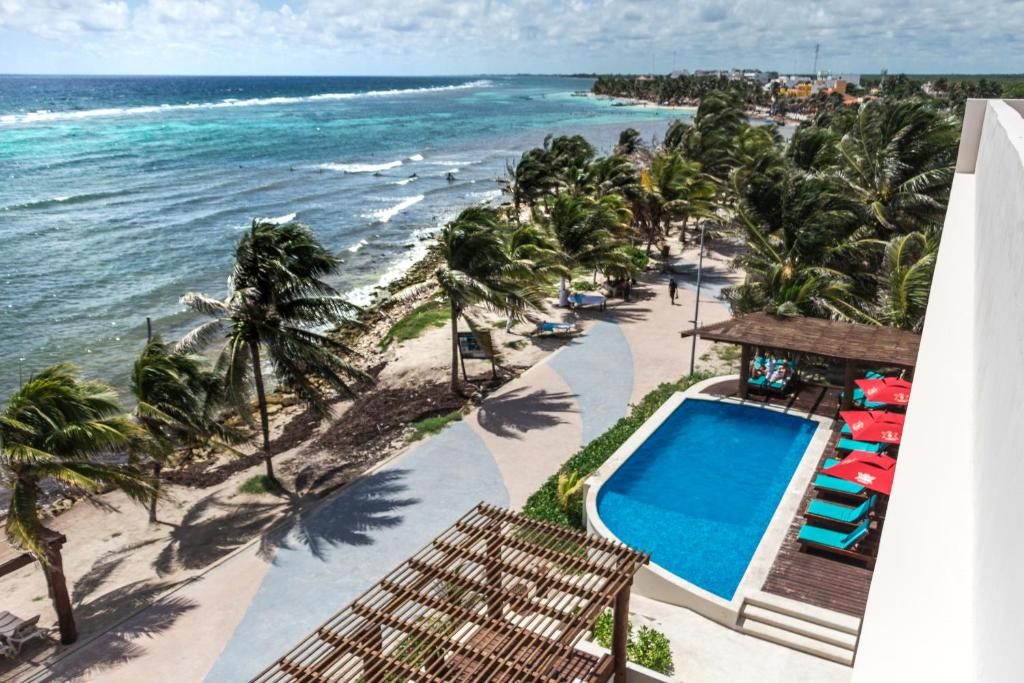 a view of the beach from the balcony of a resort at Aquastar Hotel & Apartments in Mahahual