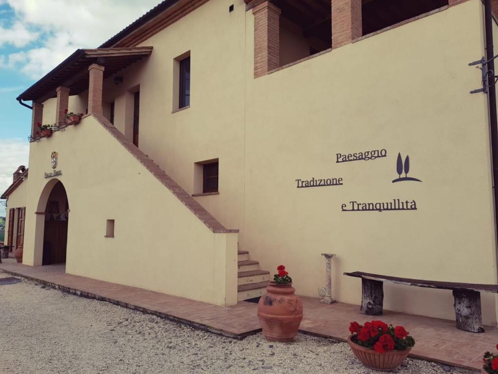 a white building with a sign on the side of it at Agriturismo Poggio Tobruk in Pienza