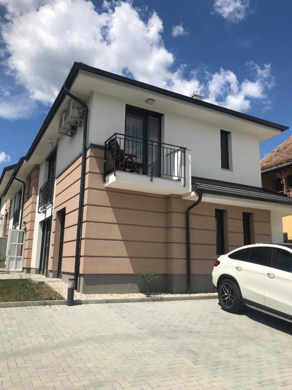 biały samochód zaparkowany przed domem w obiekcie Edmond Apartment w Hévízie