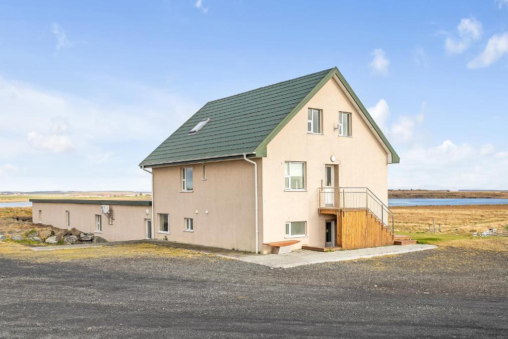 a large house with a green roof at Guesthouse Vatnsholt in Vatnsholt