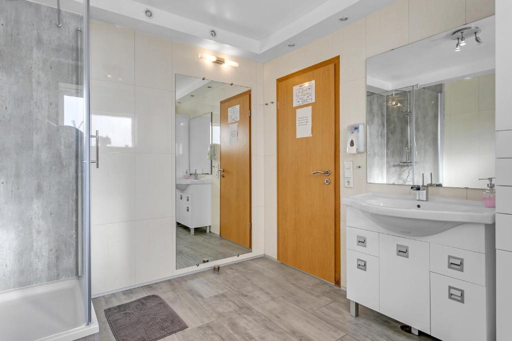 a bathroom with a sink and a shower and a mirror at Guesthouse Vatnsholt in Vatnsholt