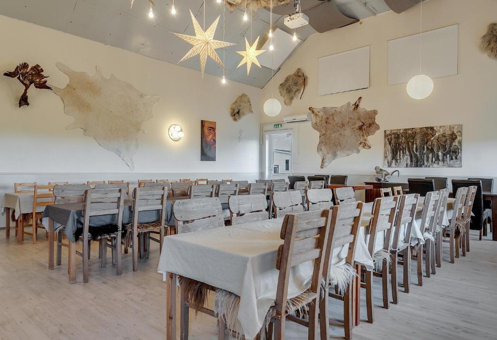 a dining room with tables and chairs in a room at Guesthouse Vatnsholt in Vatnsholt