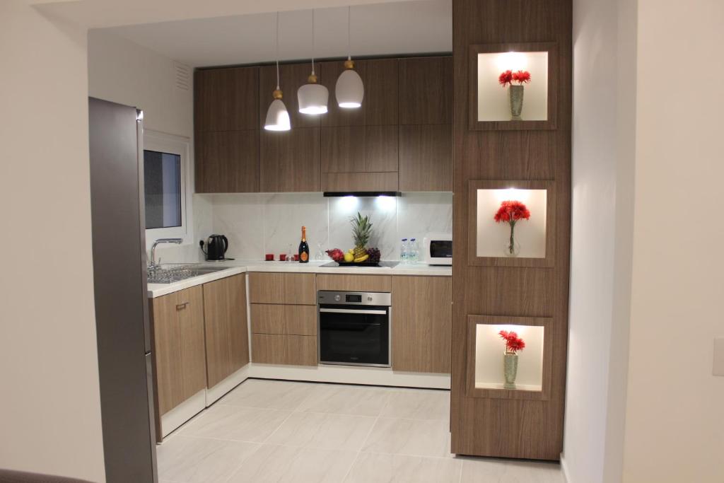 a kitchen with wooden cabinets and red flowers on the wall at SUNCITY in Limassol